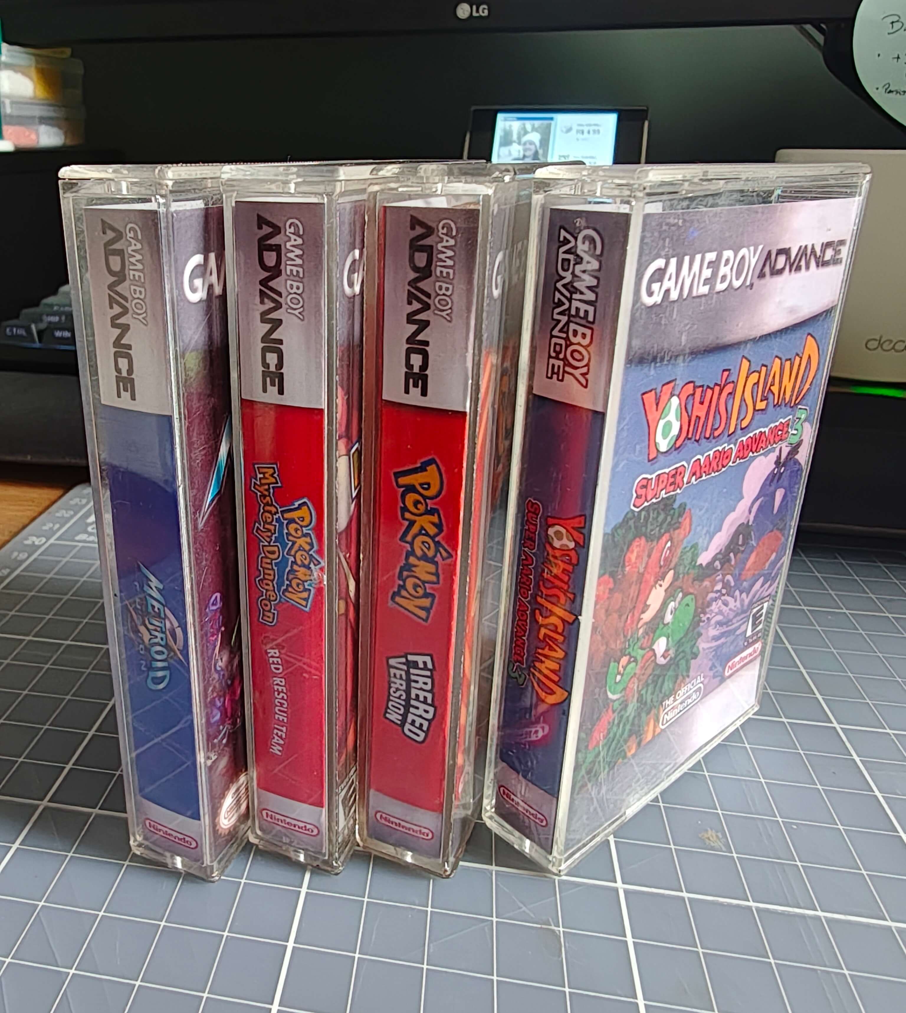 Quatro capas de fita cassete com encartes de jogos de GBA: Metroid, Pokémon Mystery Dungeon, Pokémon FireRed e Yoshi's Island